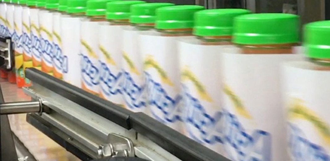 Actipro protein drink bottles traveling on conveyor from sleever to shrink tunnel.
