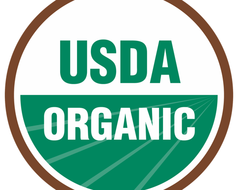 USDA organic seal over a background of red and blue berries.
